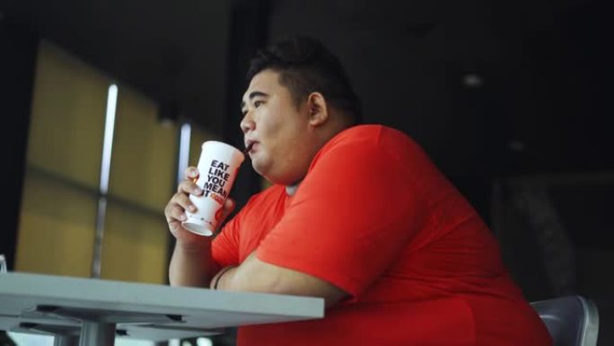 肥胖男子在咖啡馆喝软饮料