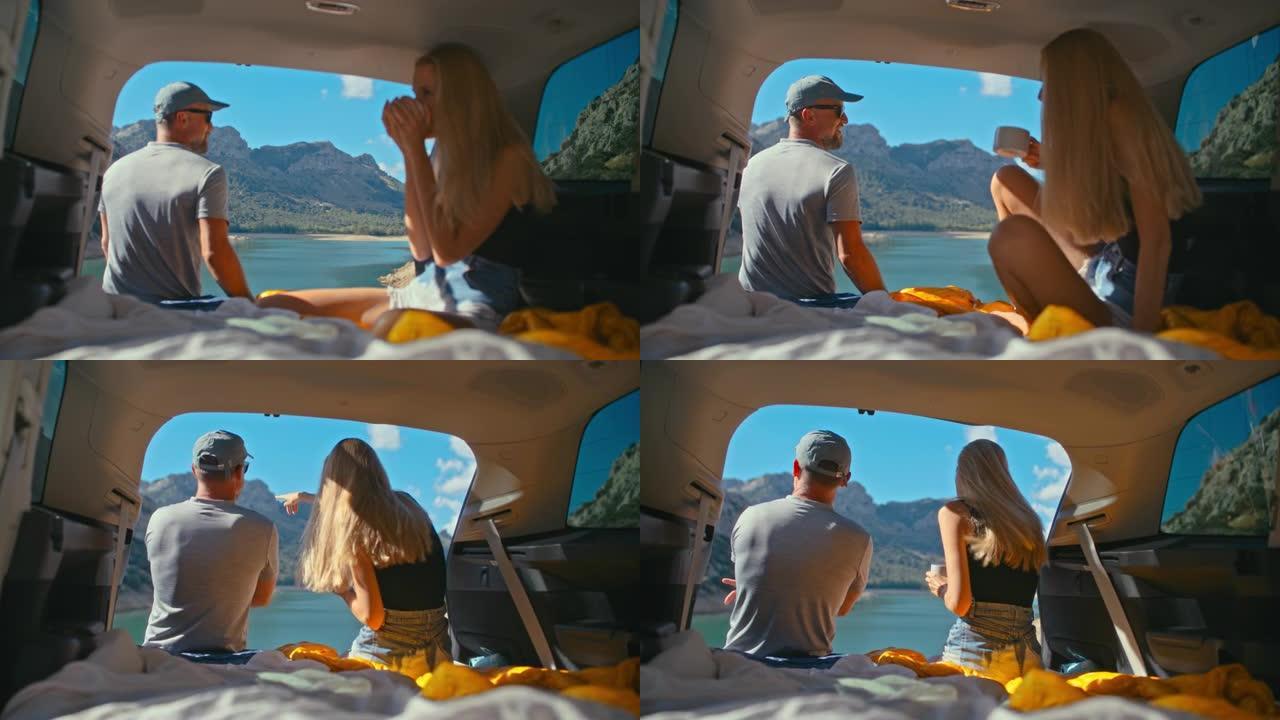 一对相爱的夫妇在湖边的一个大型汽车后备箱里一起休息和露营。喝茶看美景