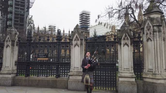 苏格兰风笛手穿着传统服装在威斯敏斯特前的街道上表演