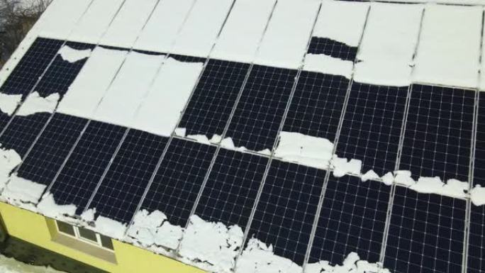 从屋顶安装的有盖太阳能光伏板上鸟瞰积雪融化，以产生清洁的电能。北方地区冬季可再生能源发电效率低