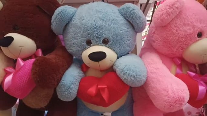 许多五颜六色的玩具泰迪熊，手里拿着红心