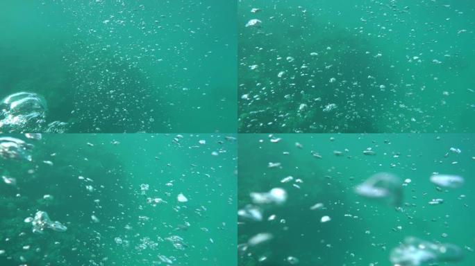 潜水员的气泡上升到蓝色大海的水面。海洋背景