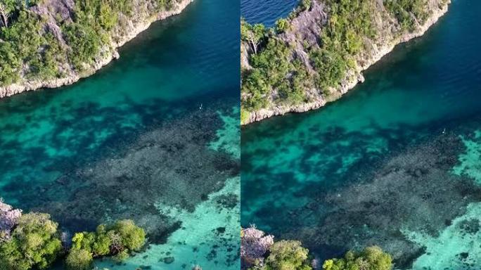 热带岩石岛的绿松石水和浅礁空中拍摄的垂直视频