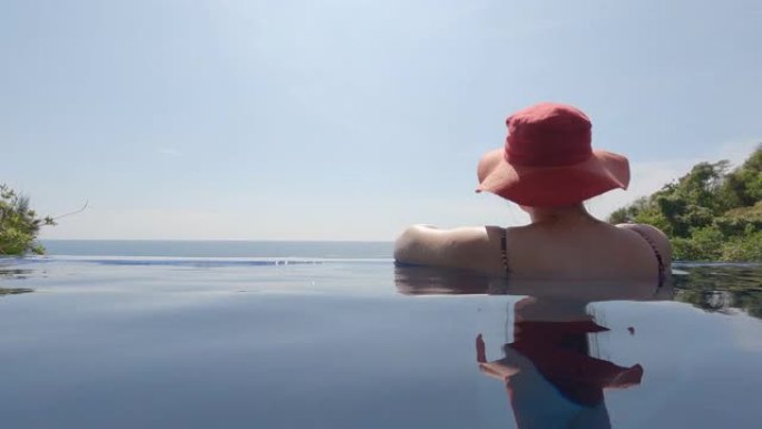 女人在无边泳池放松