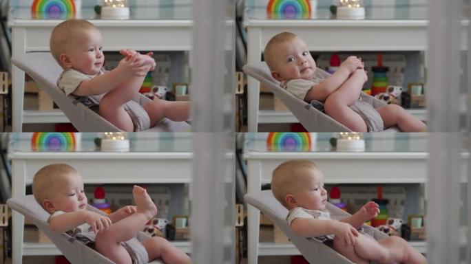 婴儿坐在摇椅上，10个月大的高加索孩子赤脚玩耍