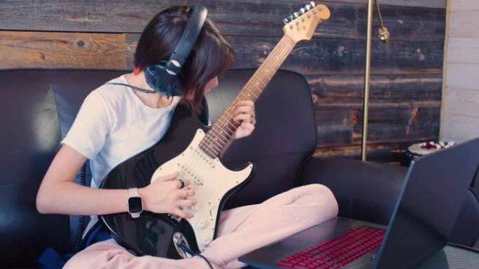 青少年女孩在网上吉他课。