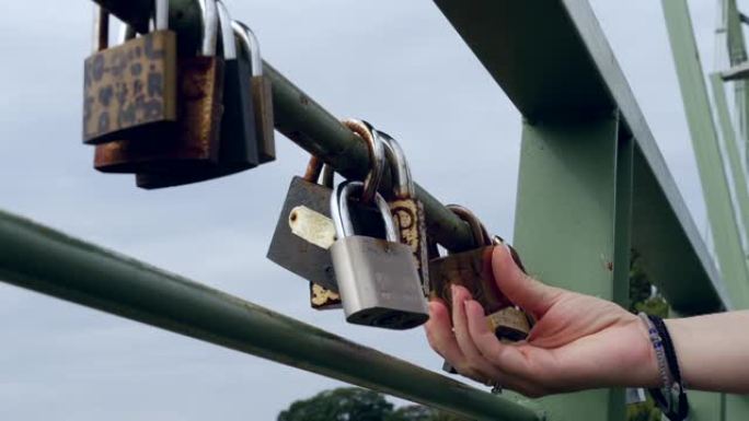 女人在桥梁的铁栏杆上研究金属挂锁，并与爱情相连52