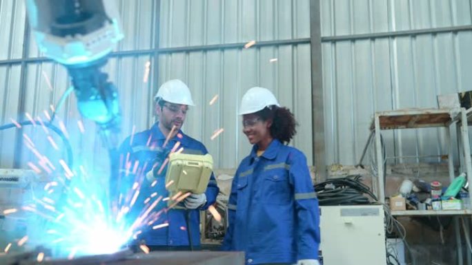 年轻的女工程师正在完成学徒制，并向高级工程师学习。当机器人焊接设备启动时，发生了微小的震动。