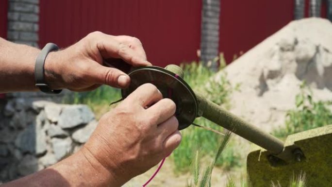 一个男人的手拆开割草机更换零件的特写镜头。通过更换零件来维护和修理除草器。