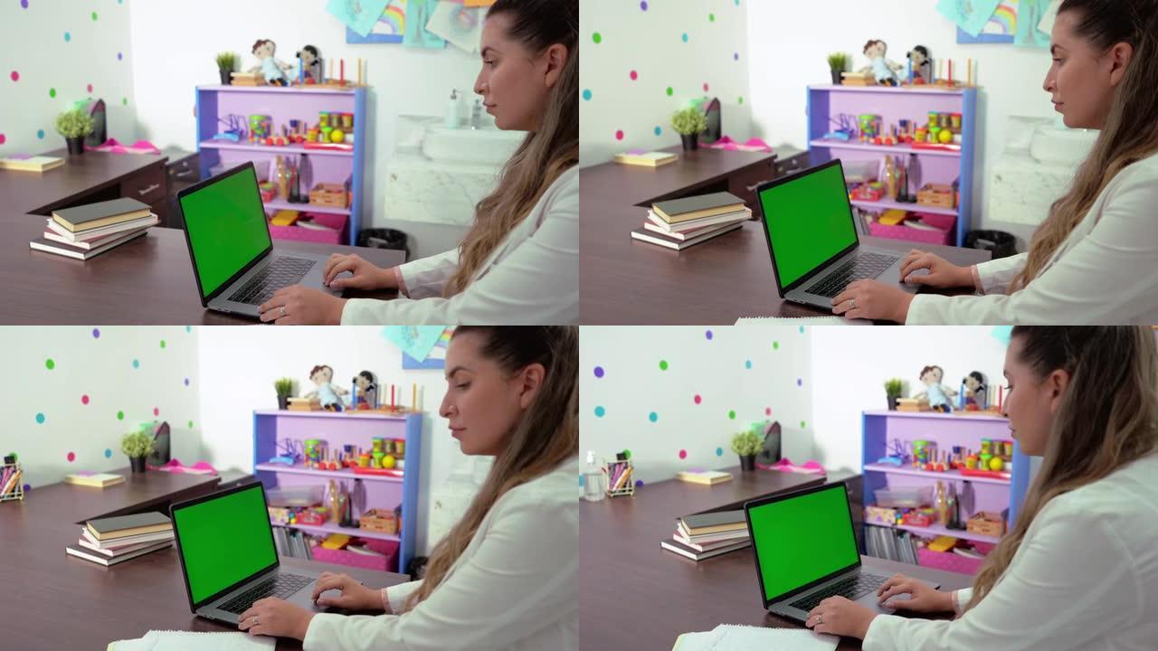 绿屏笔记本电脑上心理学家打字的侧视图