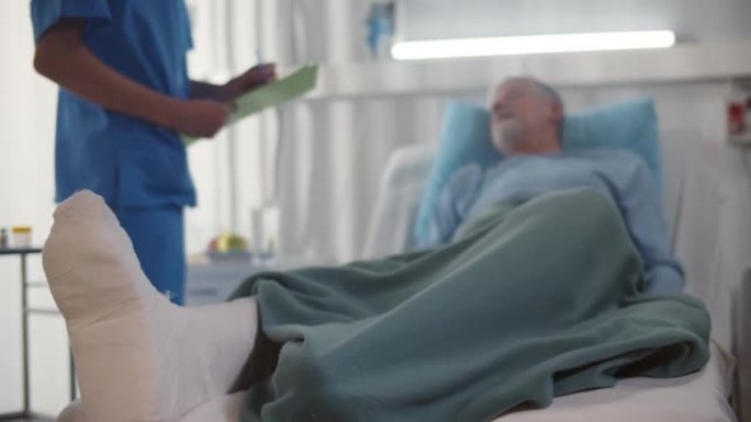 医生与躺在医院病床上的断腿老人交谈