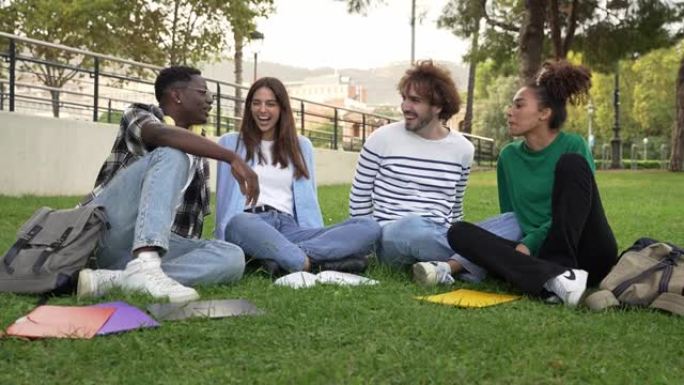 大学生朋友坐在草地上畅谈分享大学校园里的瞬间