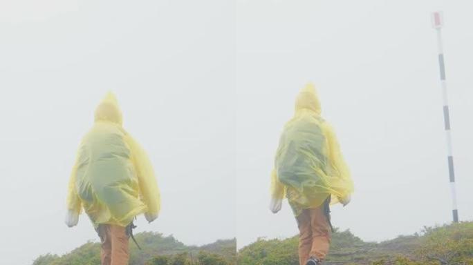 垂直屏幕女徒步旅行者在雾蒙蒙的雨中探索自然。