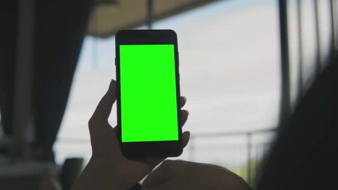 女人在家使用绿屏智能手机