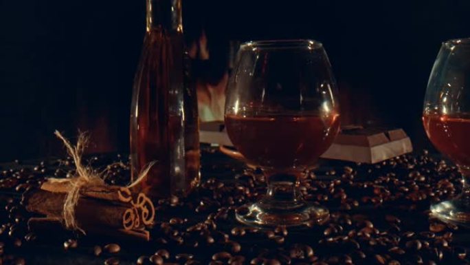 玻璃杯和一瓶威士忌，巧克力棒和肉桂棒放在桌子上，散落着咖啡粒