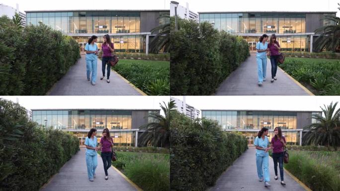 快乐拉丁美洲护士协助一名缓解的女病人出院