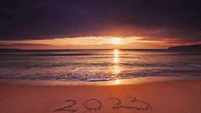 2023欢迎新年文本在海洋日出期间在海边。海滩日落和海浪洗沙，4k视频带声音