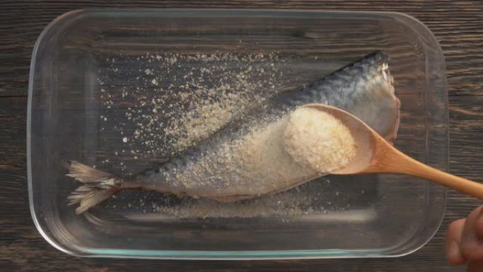 用盐，糖，柠檬皮的混合物从勺子中撒上鲭鱼