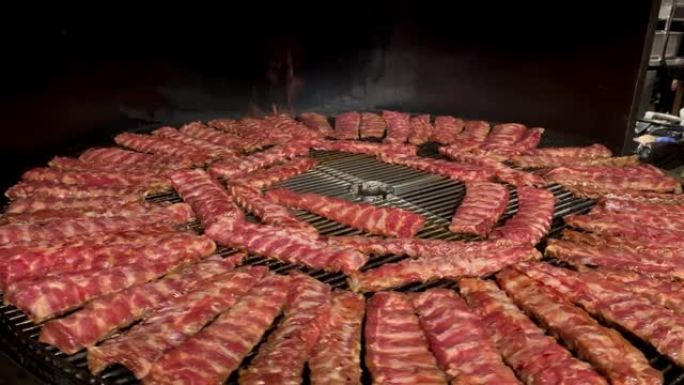 许多排骨在街头市场或餐馆出售的大型自动圆形烤架上烤。