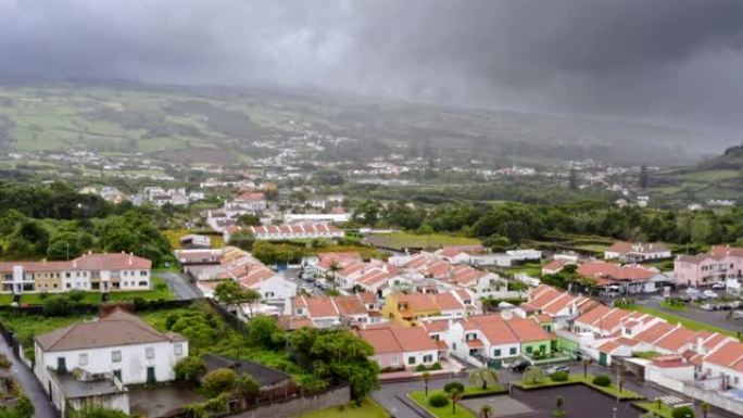 亚速尔群岛的山坡小镇在黑暗的暴风云下，鸟瞰图。