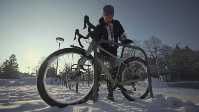 冬季下雪的天气，骑自行车的人将自行车锁在欧洲的街道停车场。锁定自行车停车。保护你的自行车免遭入室盗窃