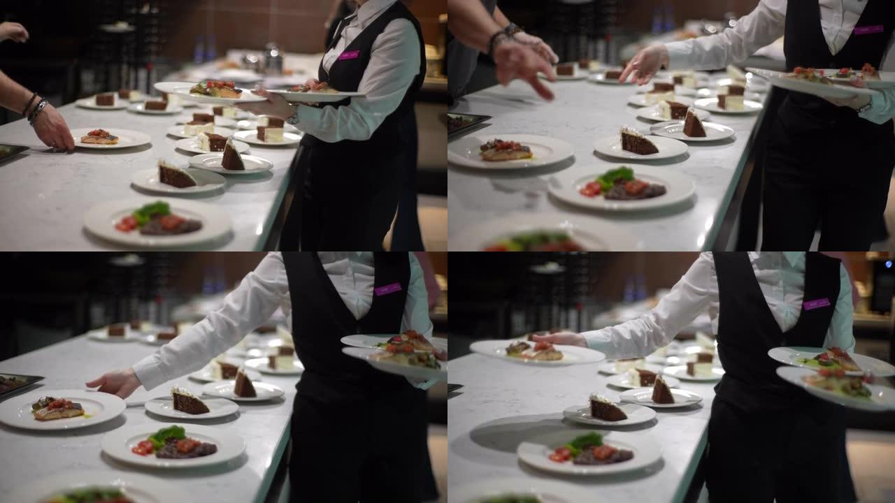 无法辨认的女服务员的特写镜头，收集即食餐盘，并将其带到餐厅宾客休息室。