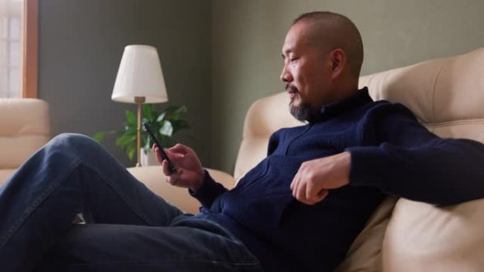 亚洲中年男子用手机阅读讯息