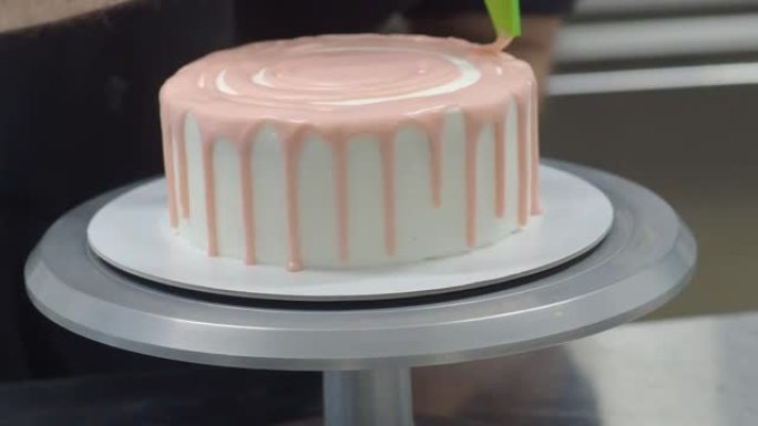 手工糕点厨师设计师在磨砂白色蛋糕上打上粉色滴灌袋4k镜头