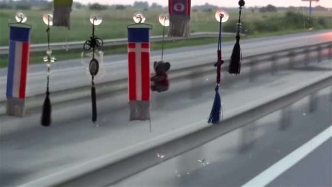 在交通繁忙的道路上，卡车挡风玻璃上悬挂的旗帜和其他装饰品