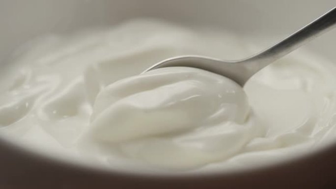 用勺子舀白酸奶的慢动作微距镜头