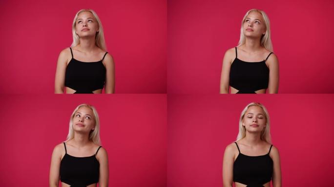 一个女孩的4k视频抬头思考粉红色背景。