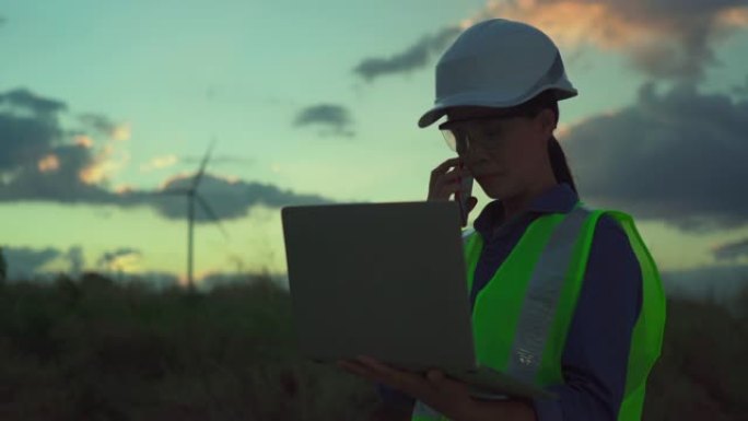 女性工程师在风力涡轮机农场户外使用平板电脑的视频。4K(UHD) 3840x2160格式。