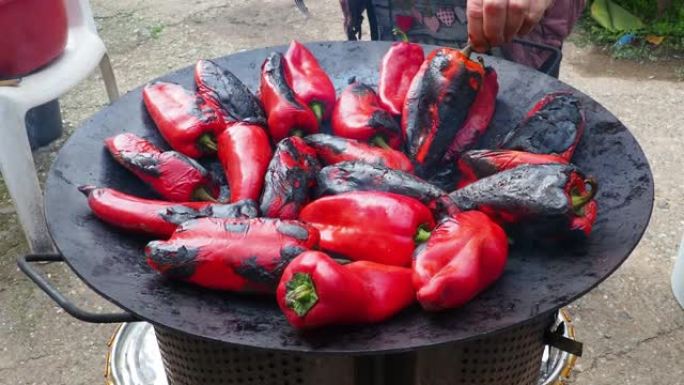 烤红辣椒，具有烟熏味和快速脱皮。辣椒作物在金属圈上的热处理。用于燃烧木炭燃料以进行烹饪，加热或文化仪