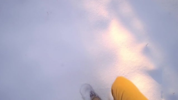 第一人称视角。男人穿着棕色的鞋子穿过深雪。
