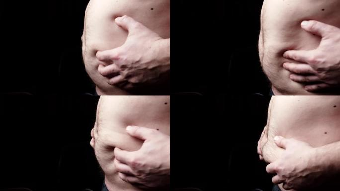 黑暗背景下男人的胖肚子。肥胖，体重问题。饮食，运动概念的时间。