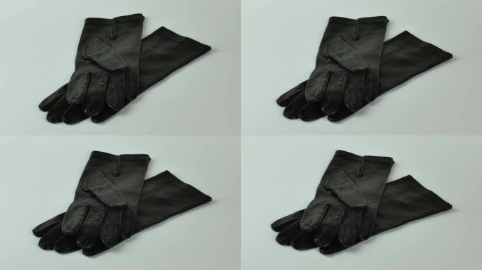 优雅的女性皮手套，背景浅。一对新的黑色皮手套，隔离在浅色背景上。寒冷季节的服装概念