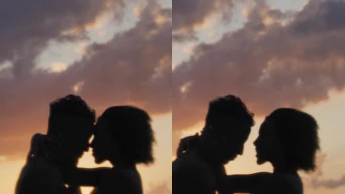 非洲民族浪漫的异性恋夫妇在日落时一起在海里游泳。互相拥抱垂直视频
