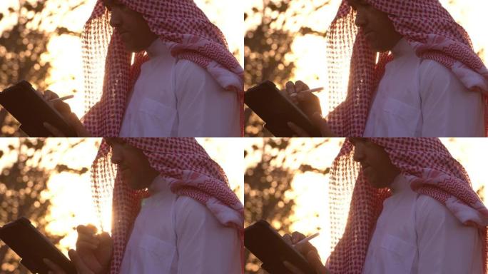 一名阿拉伯男子正在用平板电脑监控自己的石油业务