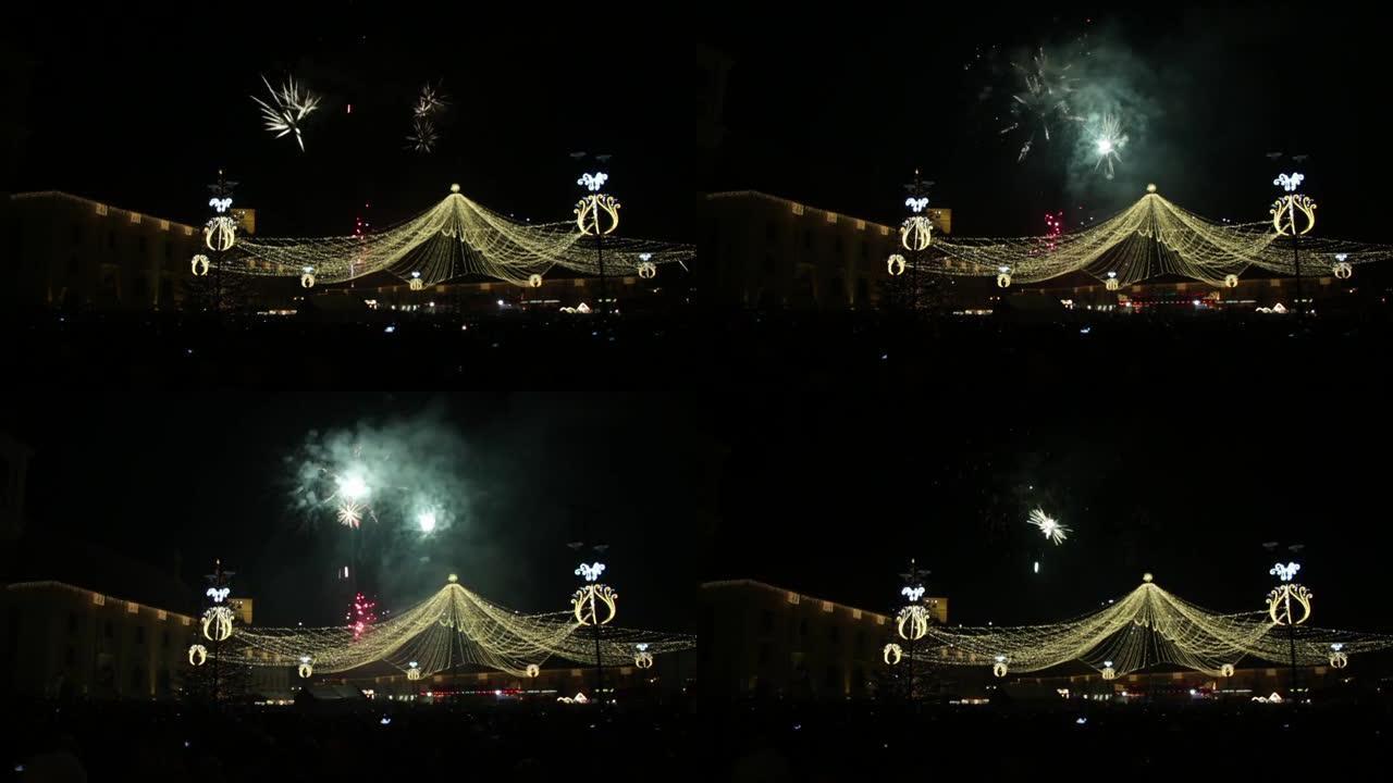 天空中五颜六色的烟花在城市中央广场上方的黑色夜晚装饰着灯饰花环71