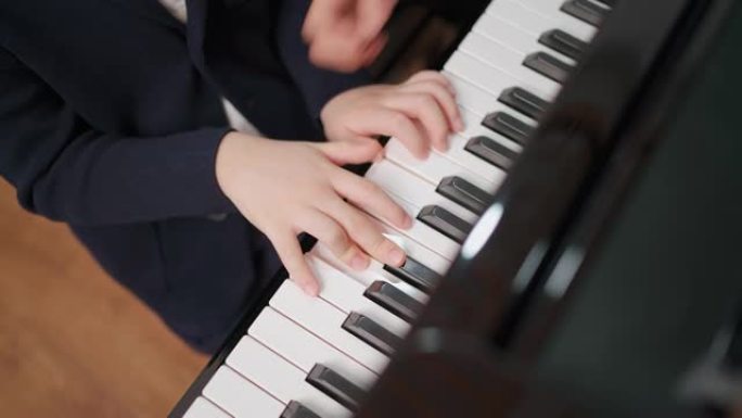 钢琴家在学校的教室里教一个男孩弹钢琴。最喜欢的古典音乐。学习期间快乐而有趣。穿着正式优雅西装的音乐家