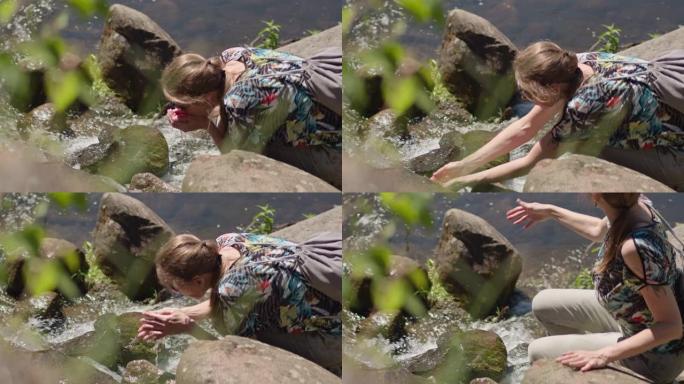 口渴的女人从山涧里舀水洗手