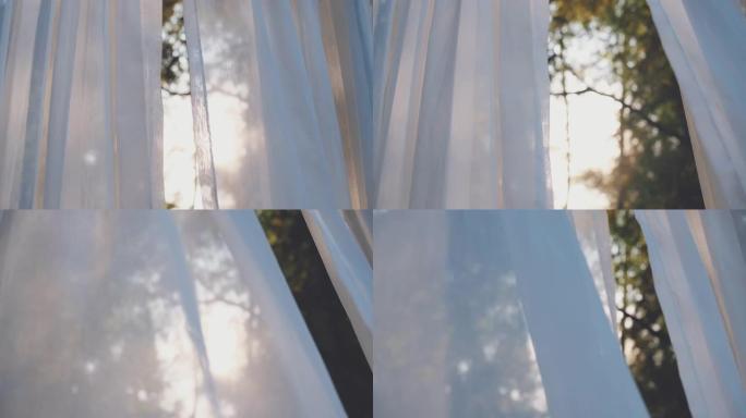 白色透明窗帘布在风吹与阳光