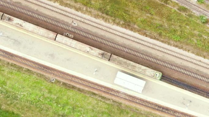 铁路货运列车货车在铁路上行驶。集装箱货物的运输和交付。在河流和燃煤电厂附近乘坐火车的鸟瞰图。