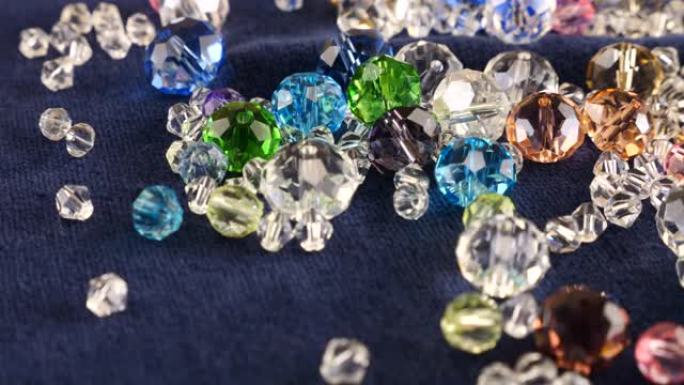 蓝色天鹅绒上的多色透明珠宝水晶和水钻。