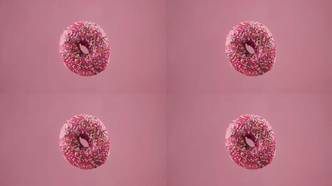 各种彩色甜甜圈。不同的美味甜甜圈在粉红色背景下变化。