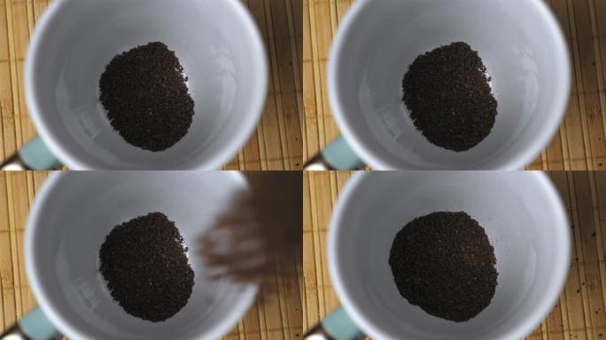 速溶黑咖啡颗粒落在白色杯子的底部。早上煮咖啡。煮咖啡的过程。