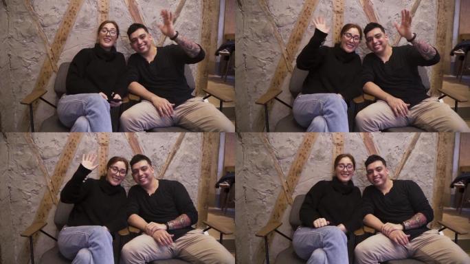 一对夫妇坐在咖啡店里向相机挥手的静态电影摄像机运动