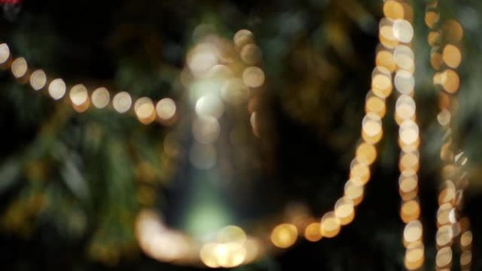 圣诞钟装饰挂在树上金色和绿色的bokeh散焦