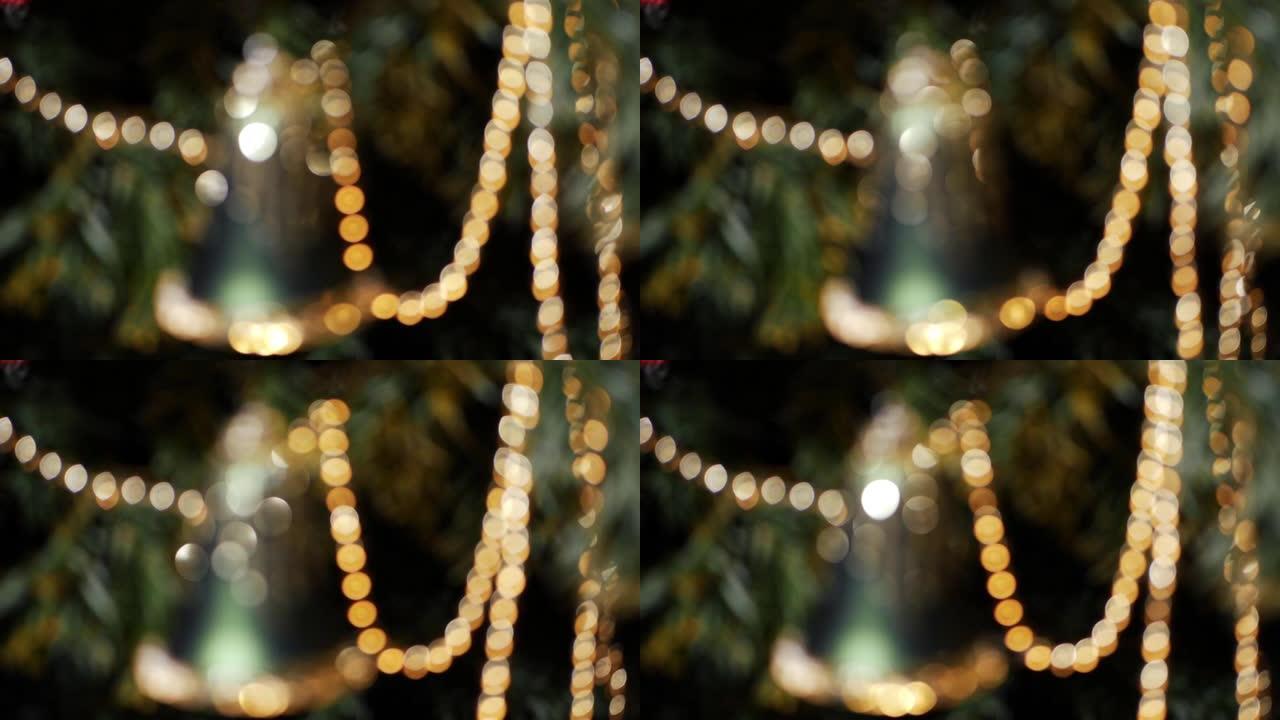 圣诞钟装饰挂在树上金色和绿色的bokeh散焦