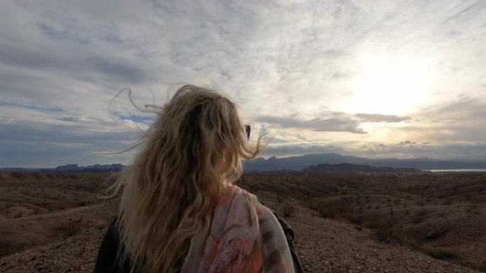 成熟的女人从沙漠山脊峰望去日出